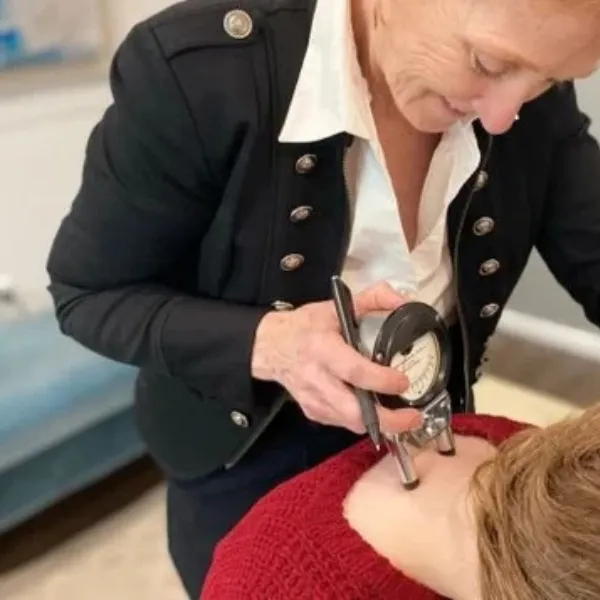 Dr. Mary Schmidt using a hand-held adjusting instrument