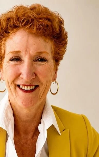Dr. Mary Schmidt smiling, in a mustard yellow jacket