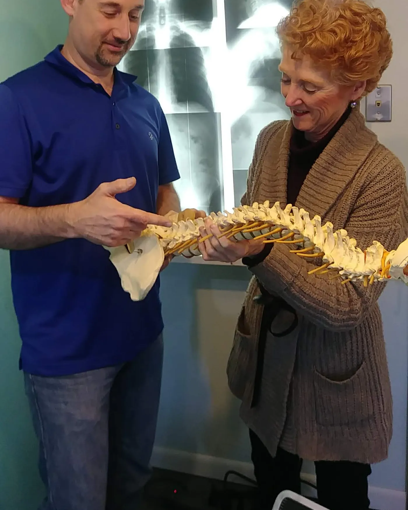 Dr. Mary Schmidt showing a patient a model of the spine